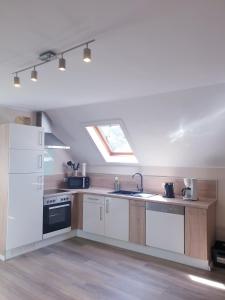 a kitchen with white appliances and a skylight at Ferienwohnung Ambiente II und III in Klotten