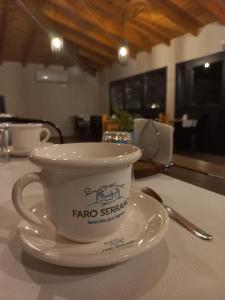 a coffee cup on a plate on a table at Hosteria Faro Serrano in Villa General Belgrano
