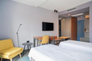 a hotel room with two beds and a table and chairs at Boutique hotel Lili in Rovinj