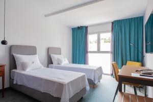 a hotel room with two beds and a desk at Boutique hotel Lili in Rovinj