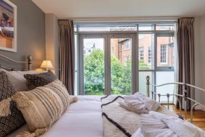 a bedroom with a bed and a large window at Luxury at The Brunswick - Free Parking-4 bedrooms in Brighton & Hove