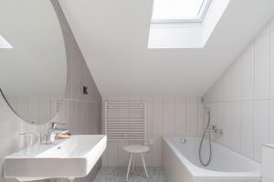 a white bathroom with a sink and a tub at Boutique hotel Lili in Rovinj