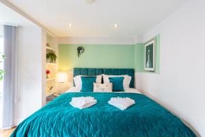 a bedroom with a blue bed with two pillows at Luxury at The Brunswick - Free Parking-4 bedrooms in Brighton & Hove