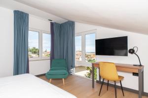 a bedroom with a desk and a computer and two chairs at Boutique hotel Lili in Rovinj