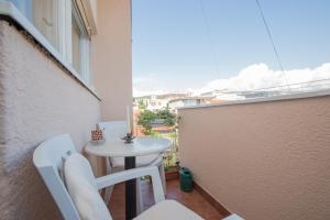 einen kleinen weißen Tisch und Stühle auf dem Balkon in der Unterkunft Apartment La Casa - Sebenico in Šibenik