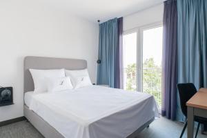 a bedroom with a white bed and a window at Boutique hotel Lili in Rovinj