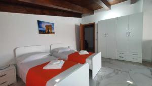 a bedroom with two beds and a bath tub at Alepou Guest House in Gasperina