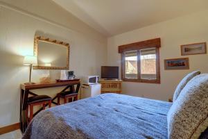 1 dormitorio con cama, escritorio y espejo en CV210A Copper Valley Hotel Room condo, en Copper Mountain