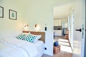 a bedroom with a bed and a hallway with a kitchen at Cisza & Spokój - Jeziora, Lasy i Drawieński Park in Człopa +11 photos