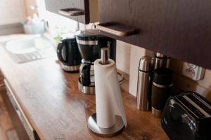 a counter with a coffee maker and a roll of paper towels at Tęcza Mazur in Kątno