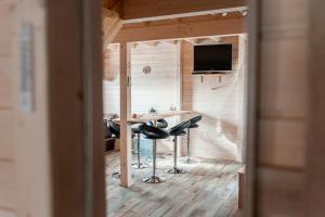 a room with a table and chairs in a tiny house at Tęcza Mazur in Kątno