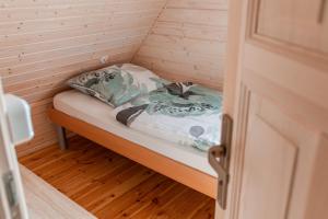 a small room with a bed in a small house at Tęcza Mazur in Kątno +14 photos
