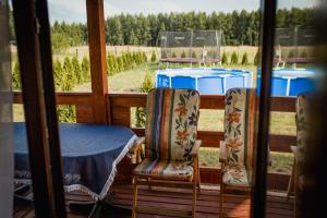 a table and chairs on a porch with a view at Tęcza Mazur in Kątno