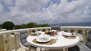 uma mesa branca com um prato de comida numa varanda em Seacruise Villa em Saint Lucy