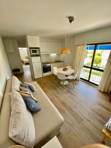 ヴィラモウラにあるVilamoura - Apartamento Praia e Golf PL IIのリビングルーム(ソファ付)、キッチン(テーブル付)