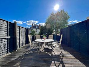 a patio with a table and chairs on a deck at Blue Belgrave in Torquay