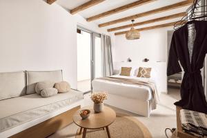 a white bedroom with a bed and a couch at Niva Pool Suites in Dhriopís