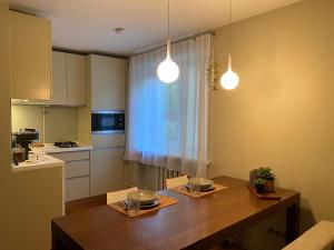 a kitchen with a wooden table and two lights at Studio apartment Ogre in Ogre