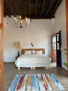 Un dormitorio con una cama grande y una lámpara de araña. en Palacio de las Rosas, en Durango