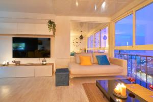 ein Wohnzimmer mit einem Sofa und einem TV in der Unterkunft Luxy Beach Apartment in Torremolinos