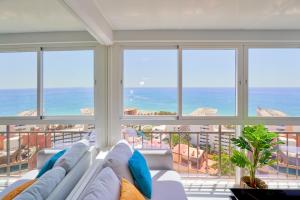 ein Wohnzimmer mit einem Sofa und Meerblick in der Unterkunft Luxy Beach Apartment in Torremolinos
