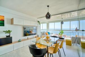 a kitchen and living room with a table and chairs at Luxy Beach Apartment in Torremolinos
