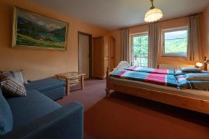 ein Schlafzimmer mit einem Bett, einem Sofa und einem Fenster in der Unterkunft Stinglhof in Železná Ruda