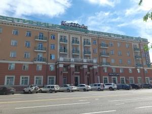 a large building with cars parked in front of it at Гостиница Караганда in Karagandy