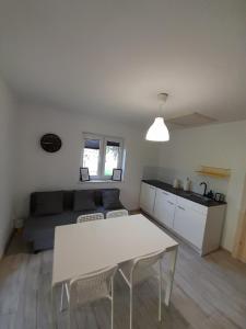 a living room with a white table and a couch at Domki u Karola Domek nr 1 in Mikołajki