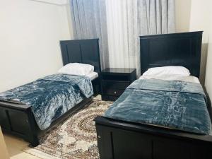 two beds sitting next to each other in a room at Eastleigh Executive Furnished Apartments next to BBS Mall in Nairobi