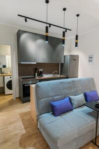 a living room with a couch and a kitchen at Stamatina's Luxury Apartment (Little Suite) in Alexandroupoli