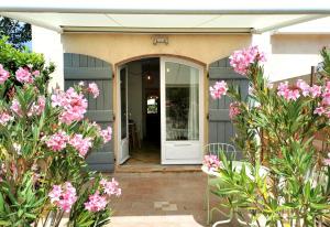 uma porta da frente de uma casa com flores cor-de-rosa em Studio 1 - LES SUITES DE ROBINSON - Résidence avec piscine en bord de Siagne, à Mandelieu-La-Napoule em Mandelieu-la-Napoule