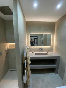 een badkamer met een wastafel en een persoon in een spiegel bij Mogador in Bonifacio