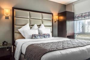 a bedroom with a large bed with a large headboard at Umbrella Hotel Bronx in Bronx