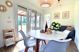 a dining room with a white table and chairs at Cisza & Spokój - Jeziora, Lasy i Drawieński Park in Człopa
