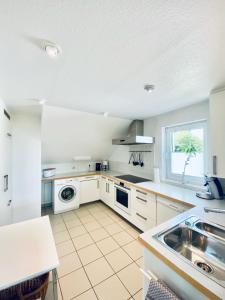 a kitchen with white cabinets and a sink at Blankensteiner Seeblick in Hattingen