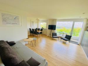 a living room with a couch and a table and chairs at Blankensteiner Seeblick in Hattingen