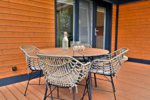 - une table en bois avec des chaises et une bouteille de vin dans l'établissement Cisza & Spokój, à Człopa