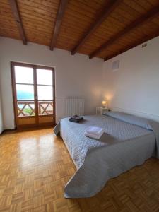 1 dormitorio con cama y ventana grande en LeonardosHome RockStairs, en Trarego