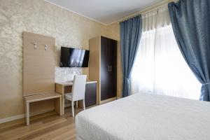 um quarto de hotel com uma cama, uma secretária e uma televisão em La Meraviglia- San Pietro - Vatican Area em Roma