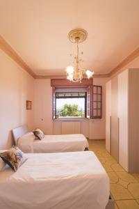 a room with three beds and a chandelier at Casa Vacanze Lavinia in Castro di Lecce