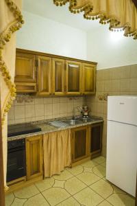 a kitchen with wooden cabinets and a sink and a refrigerator at Casa Vacanze Lavinia in Castro di Lecce +19 photos