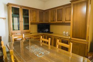 a kitchen with a glass table and wooden cabinets at Casa Vacanze Lavinia in Castro di Lecce