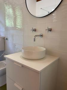 Baño blanco con lavabo y espejo en LeonardosHome RockStairs, en Trarego