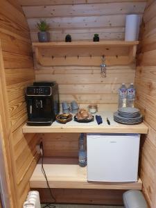 una cucina in una cabina di legno con forno a microonde e cibo di Purenes - Barrel shaped pod with hot tube a Sliseri