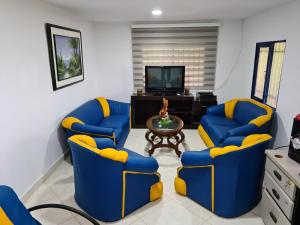 sala de estar con 2 sillas azules y mesa en Finca Hotel Alto la María, en Angelópolis
