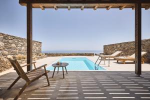 Villa con piscina, mesa y sillas en Niva Pool Suites, en Dhriopís