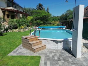 a swimming pool with a deck and stairs around it at Marianna Apartman in Gyenesdiás