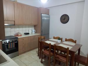 a kitchen with a table and a clock on the wall at Elena House in Kalamaki Heraklion