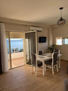 a dining room with a table and chairs and the ocean at Lotus Apartments in Vlorë